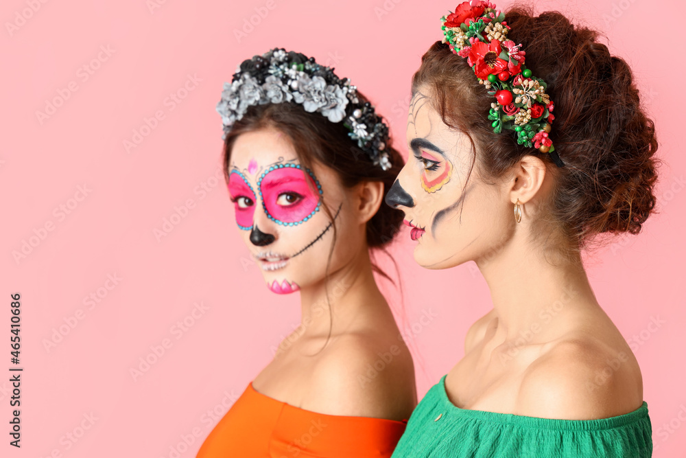 Obraz premium Stylish women with painted skull on faces against color background. Celebration of Mexico's Day of the Dead (El Dia de Muertos)