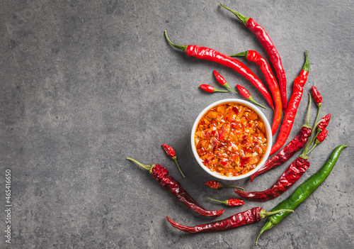 Print op canvas Chili oil sauce chili peppers flakes in oil dark background copy space