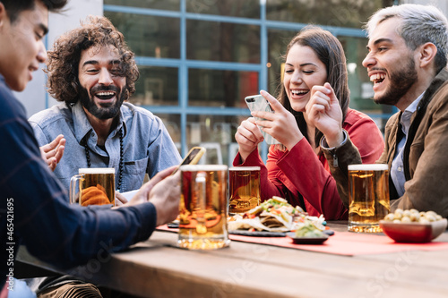 Fotografi Group of happy friends enjoying a beer and food in outdoors bar pub in the after