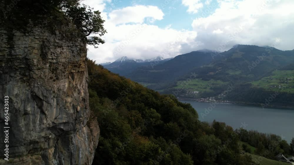 Aerial flight next a rocky mountain cliff to establish wonderful lake panorama Aerial flight next a rocky mountain cliff to establish wonderful lake panorama