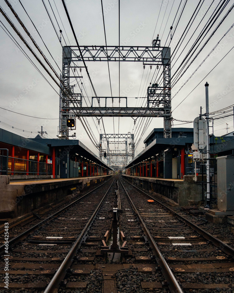 symmetrical shot of train station rails during cloudy day symmetrical shot of train station rails during cloudy day