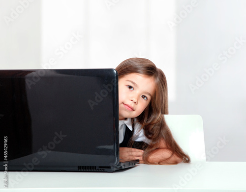 Happy and cute teen school girl sitting on laptop © Thaut Images