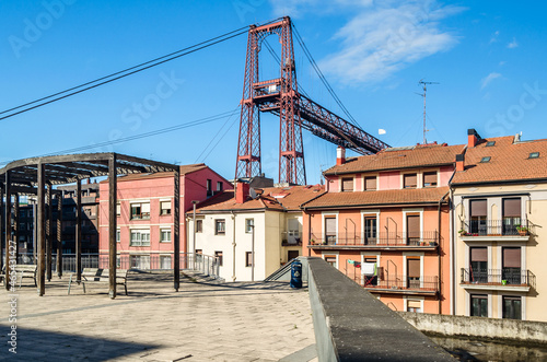 Colorful facades in Portugalete old town, with the famous Vizcaya Bridge in the background © vli86