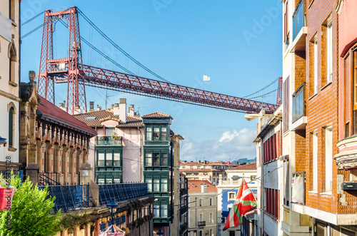 Colorful facades in Portugalete old town, with the famous Vizcaya Bridge in the background © vli86