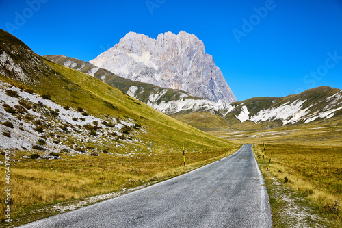 Fototapeta Narrow road in Gran Sasso e Monti della Laga National Park under the sunlight in