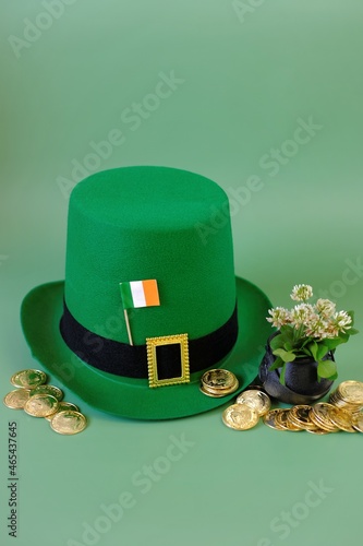 St.Patrick 's Day.Green leprechaun hat, flag of Ireland, bowler hat with gold coins, bunch of clovers on a green background.St patrick's day background photo