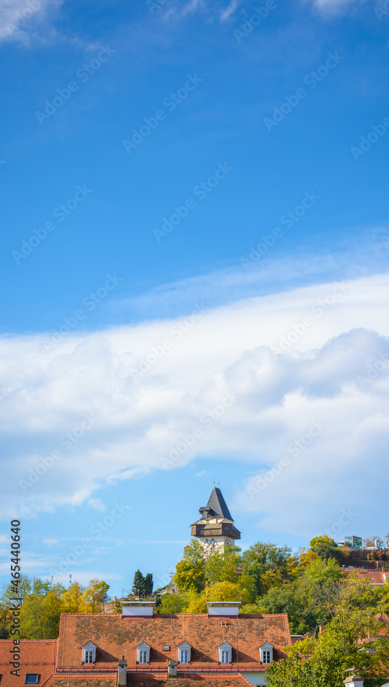 View of the Schlossberg Clock Tower in the distance in Graz against the blue sky