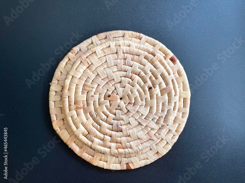 Round shape woven placemat on black background, handmade kitchenware made from dried water hyacinth, weave craft product
