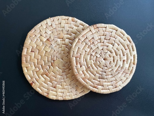 Round shape woven placemat on black background, handmade kitchenware made from dried water hyacinth, weave craft product