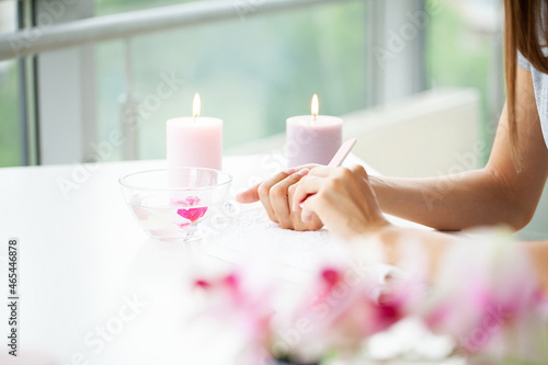 Woman hands receiving a manicure in beauty salon.