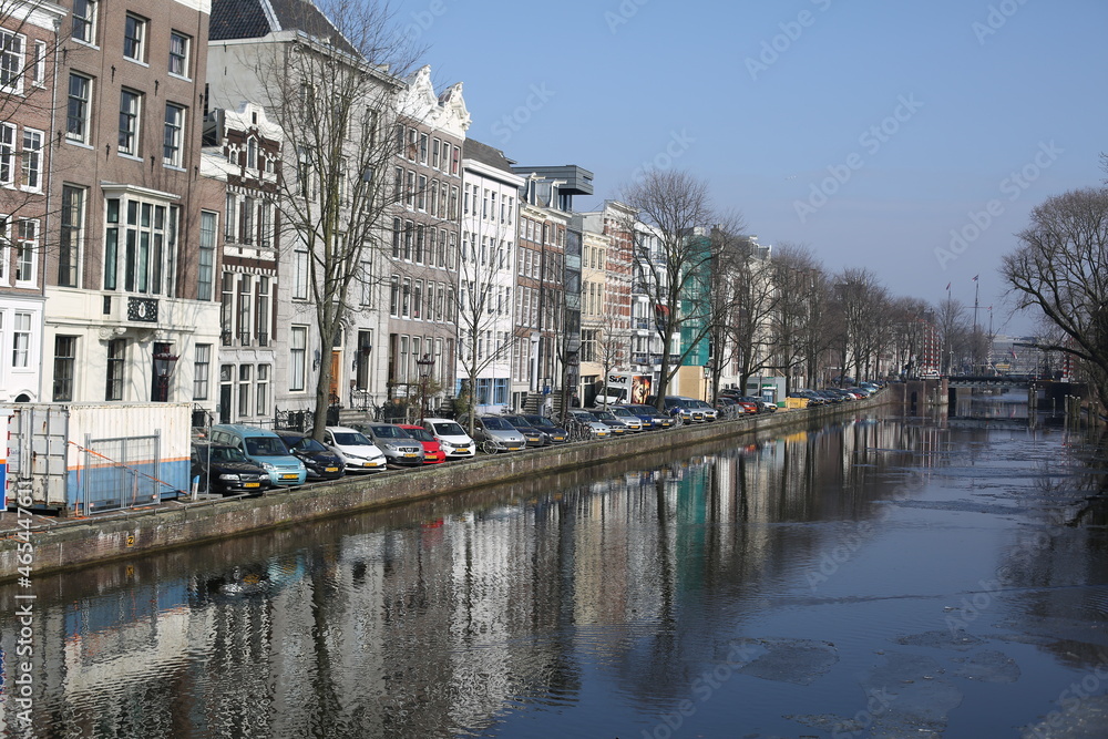 cityscape of traditional brick houses and canal in winter amsterdam