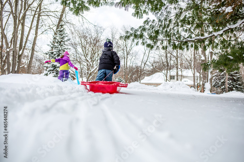 Young children pulling a sled outdoors during winter photo