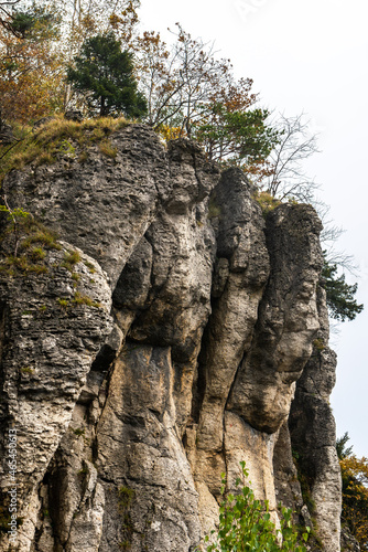 The Röthelfels with trees in bright autumn colors and further rocks at Gößweinstein, Franconian Switzerland, Germany