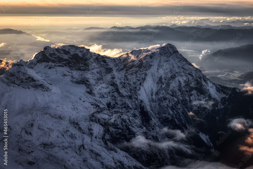 Aerial View of Canadian Rocky Mountains with snow on top during Fall Season Sunset. Nature Landscape located near Chilliwack, East of Vancouver, British Columbia, Canada. Moody