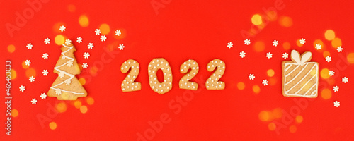 Happy New Year s set of numbers 2022  gingerbread House and gift from ginger biscuits glazed sugar icing decoration on red background  minimal seasonal pandemic winter holiday banner  stay home