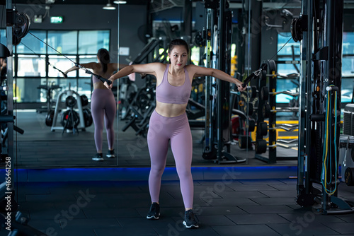 Beautiful young caucasian female athlete exercising with cable crossover machine in fitness Gym © preebangsaen