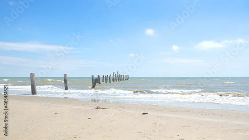 Abandoned pier concrete pole in old town beside sand beach in summer season.