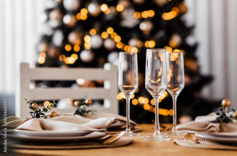 Beautiful set up indoor. Served table with three empty champagne glasses, warm colors, blurred background.