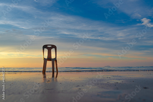 Old white chair on the beach in Thailand a beautiful morning sky
