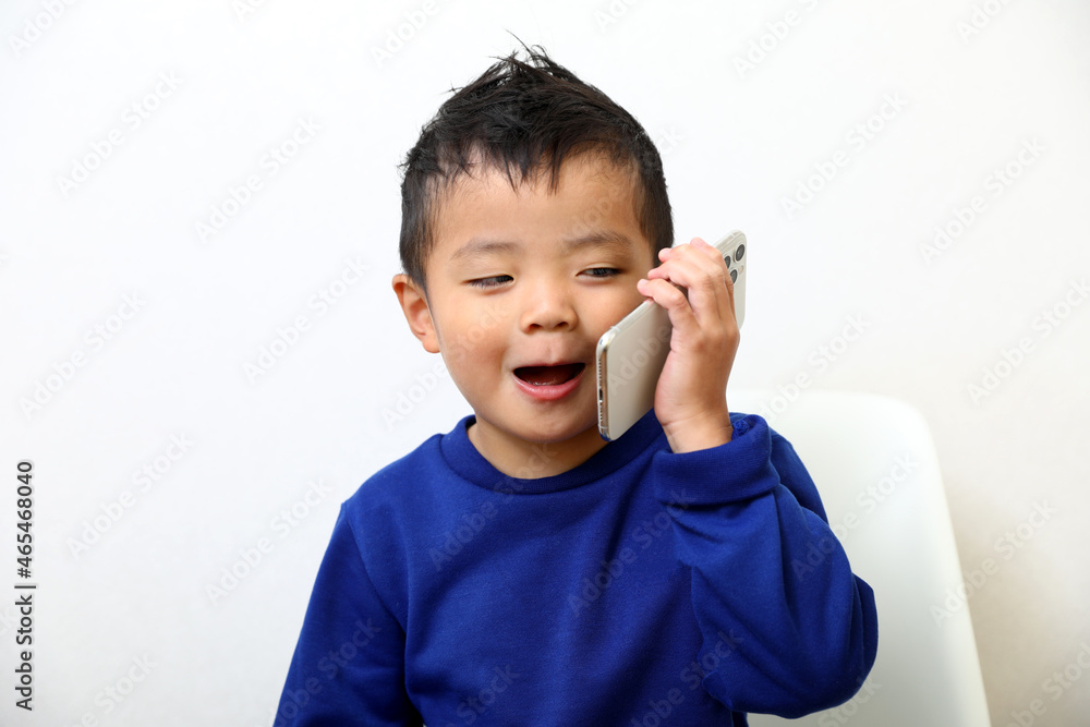 スマートフォンで電話を楽しむ男の子。 スマートフォンで電話を楽しむ男の子。