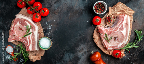 Fresh raw pork meat with ingredients ready for cooking on black table. Long banner format. top view