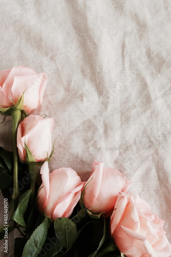 Fototapeta Naklejka Na Ścianę i Meble -  Pink roses  bouquet on beige linen texture  top view, copy space. Flowers background. Poster