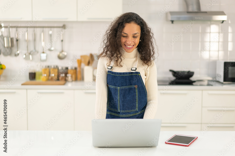 Latin woman searching recipe for cooking in kitchen Latin woman searching recipe for cooking in kitchen