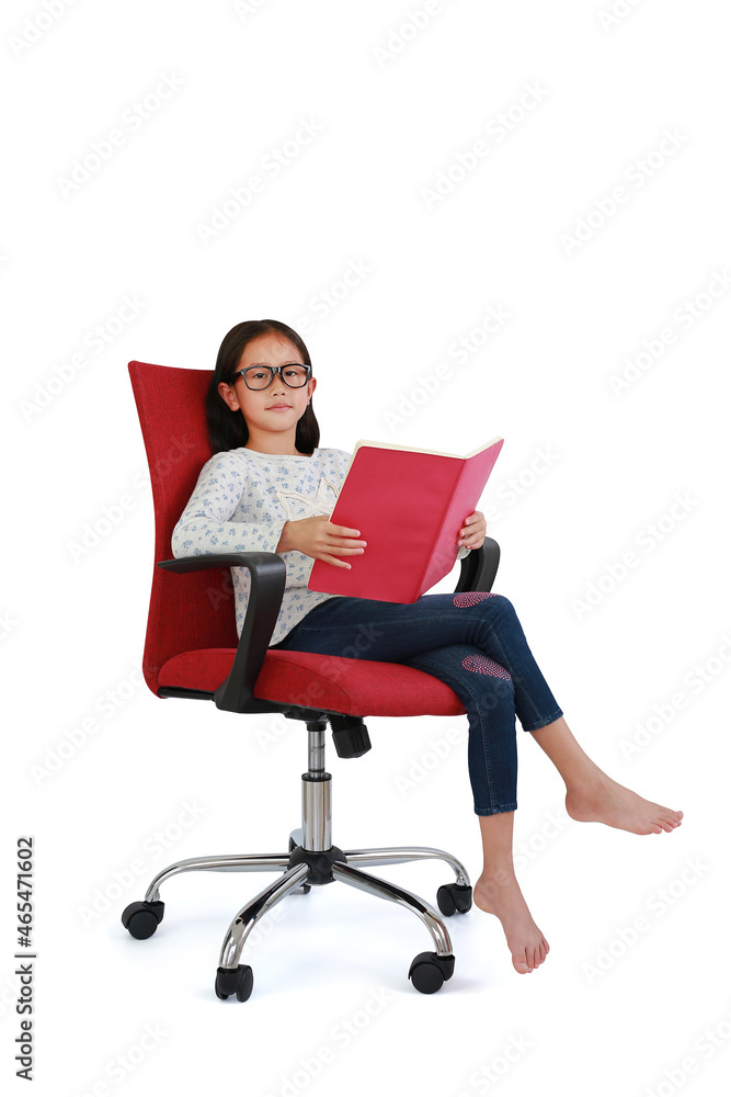Asian girl read a book sitting on red fabric chair and look at camera isolated on white background. Image full length with Clipping path.
