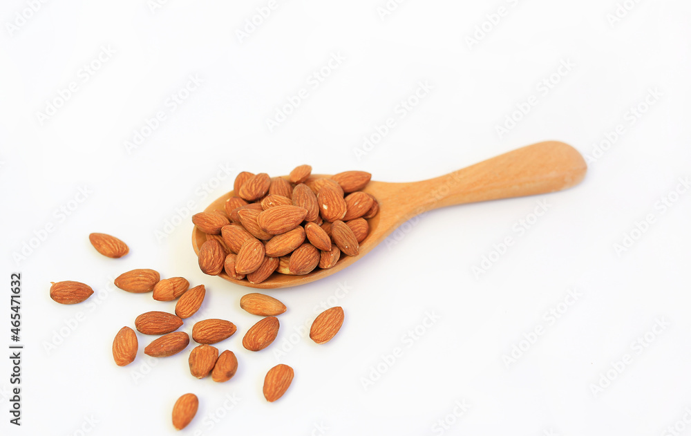 Almonds nuts in wooden spoon isolated on a white background. Almonds nuts in wooden spoon isolated on a white background.