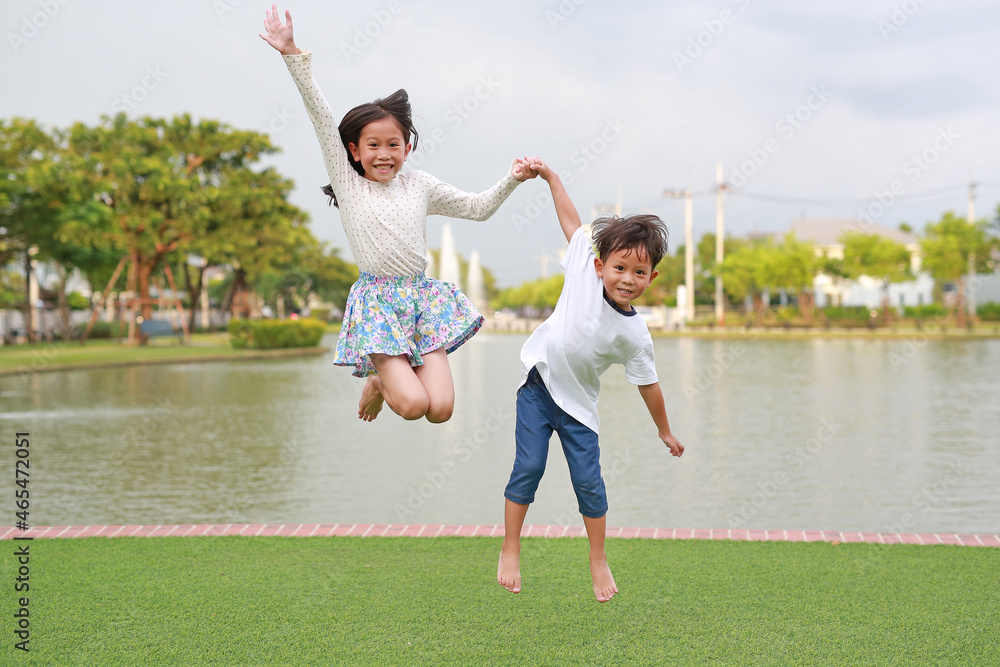 Happy Asian little boy and girl child jumping together in the garden ...