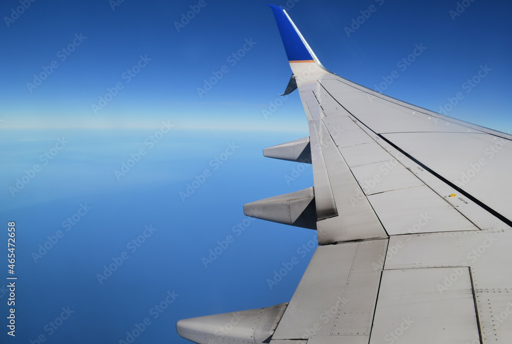 Aerial view of the ocean from a plane window with wing Aerial view of the ocean from a plane window with wing