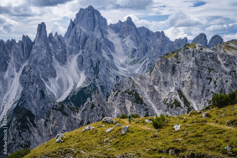 Woman hiker with backpack against Cadini di Misurina mountain group range of Italian Alps, Dolomites, Italy, Europe