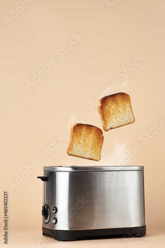 Slices of the hot toast jumping out of the toaster.
