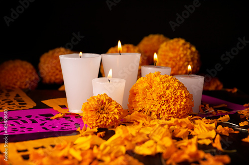 Candles with Cempasuchil orange flowers or Marigold. (Tagetes erecta) and Papel Picado. Decoration traditionally used in altars for the celebration of the day of the dead in Mexico photo