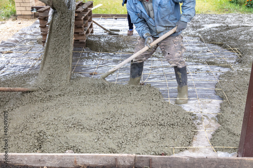 Workers level out the concrete mix at a construction site.