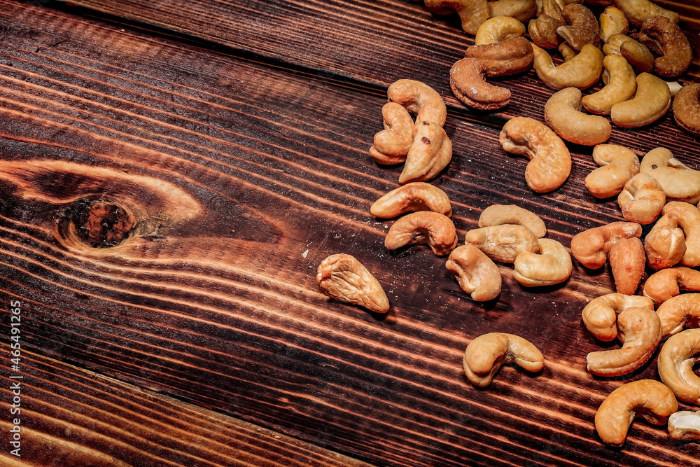 Fototapeta premium a handful of cashews are scattered on a wooden table. place for the inscription