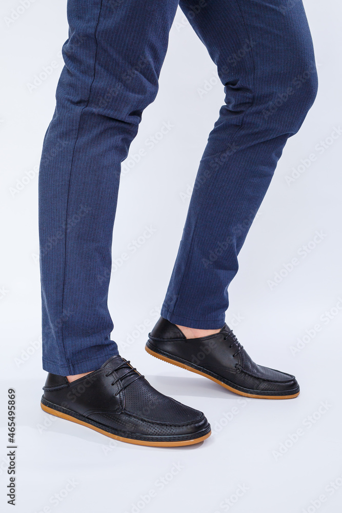 A man is wearing classic black shoes made of natural leather on lace, shoes for men under business style A man is wearing classic black shoes made of natural leather on lace, shoes for men under business style