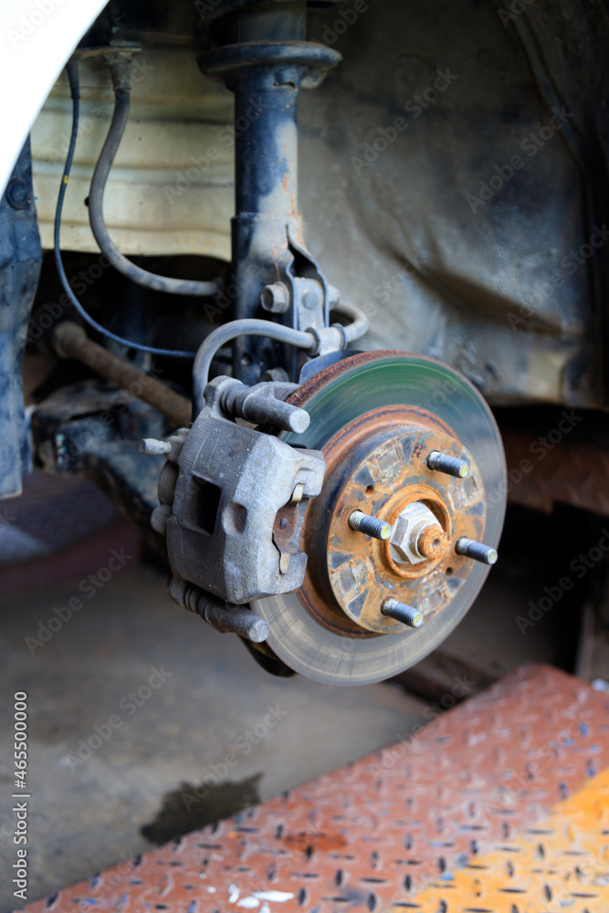 The wheel hub of the car with removed the wheel for brake and tire maintenance, the car jack lifting the car for service The wheel hub of the car with removed the wheel for brake and tire maintenance, the car jack lifting the car for service