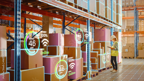 Futuristic Technology Retail Warehouse: Worker Starts Inventory Digitalization with Barcode Scanner Analyzes Goods, Cardboard Boxes, Products. Delivery Infographics in Logistics, Distribution Center photo