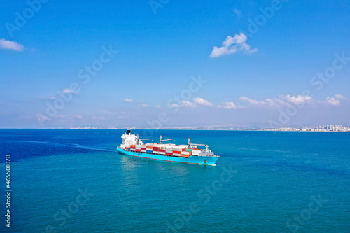 Container ship at sea approaching a commercial port.