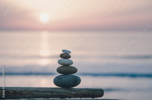 Fotografia Stone Cairn At Seaside Sunset