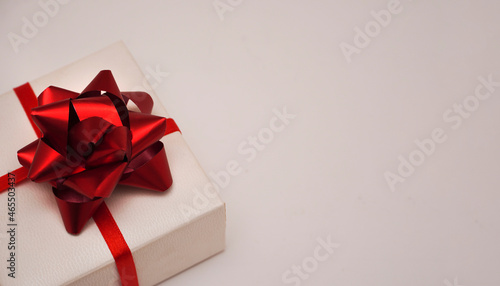  White gift textured box with red bow on white background. Christmas, New Year, Birthday, shopping sales concept. Banner. Copy space.