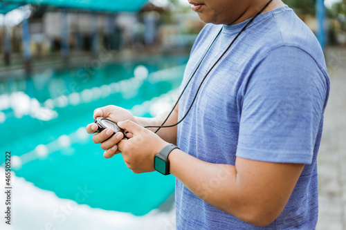 hands of an instructor holding and setting a stopwatch