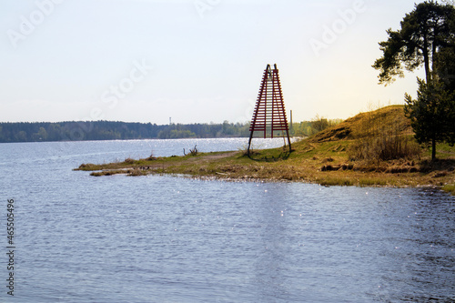 Tranquil riverscape with river bend, piece of coastline and shore navigation mark