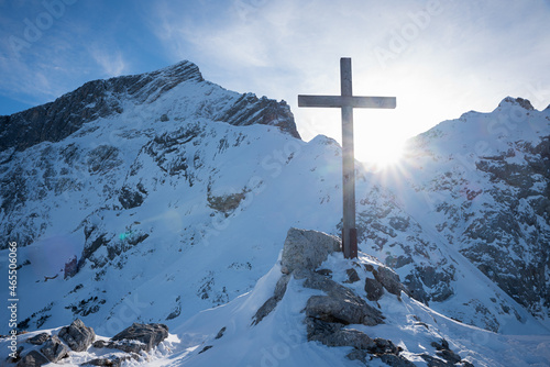 mountain cross at Osterfelderkopf summit, view to alpspitze, sunny day in winter