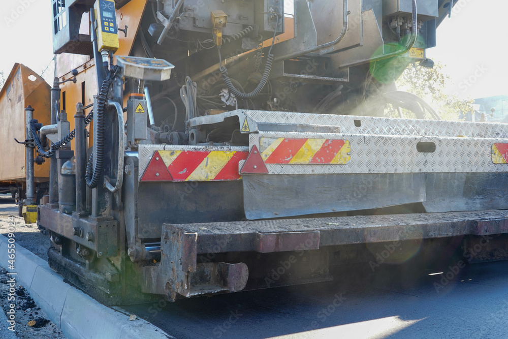 Photo of an asphalt paver on the road on the street in the city Photo of an asphalt paver on the road on the street in the city