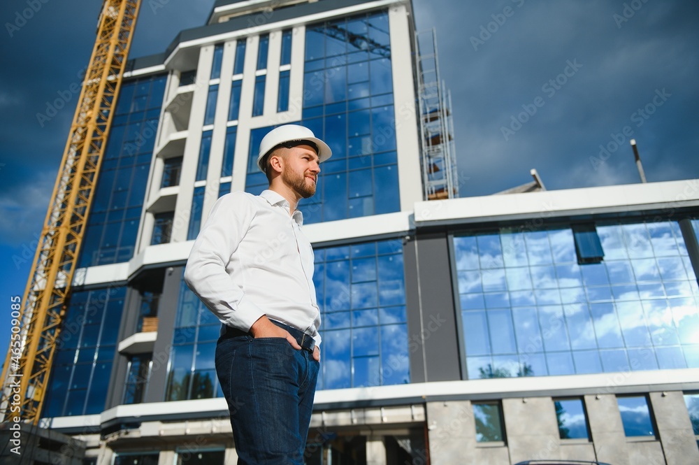 A construction worker control in the construction of roof structures on construction site and sunset background A construction worker control in the construction of roof structures on construction site and sunset background