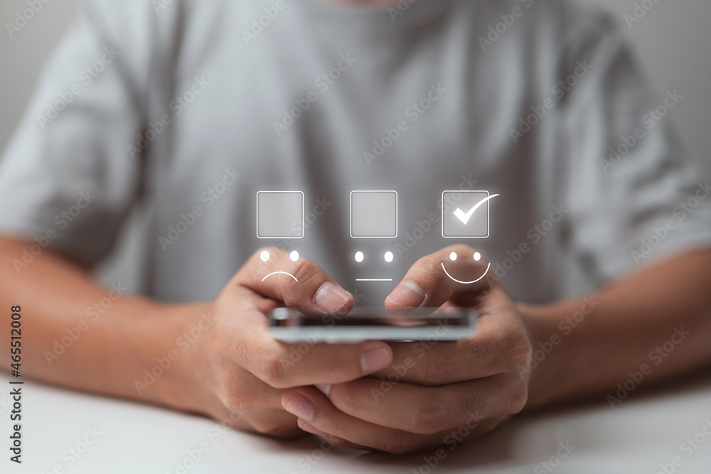 Fototapeta premium A businessman uses smartphone to make a smiling face on the touch screen.