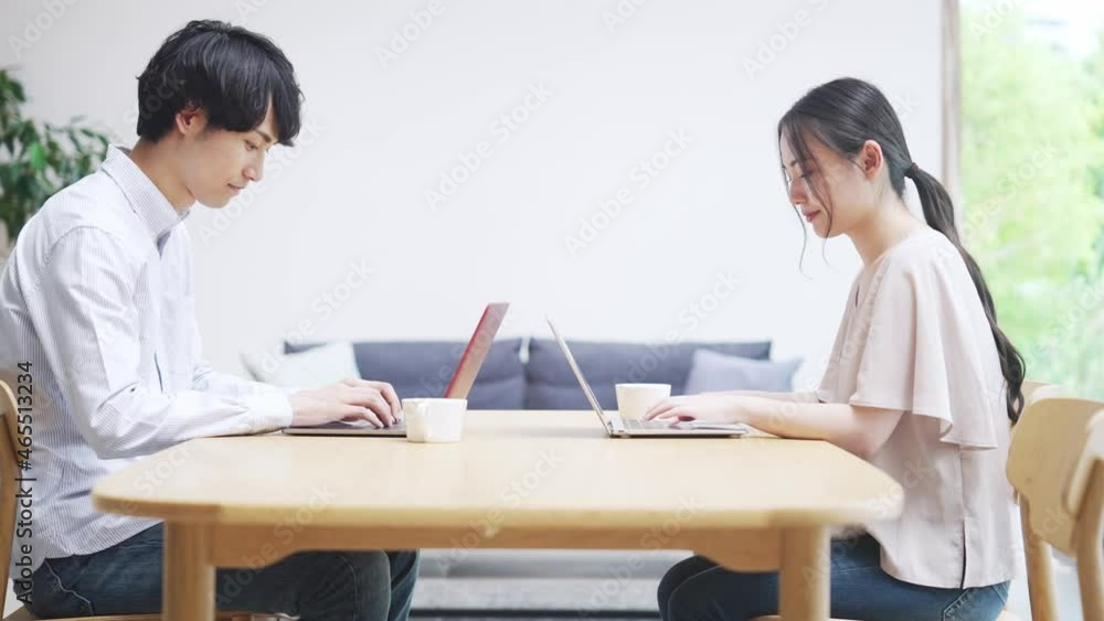部屋でパソコンを使う男女　ドリーイン 