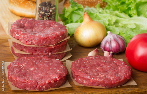 set of raw burger ingredients on wooden table